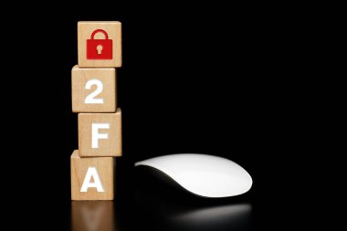 Wooden block with the word 2FA and a mouse on a dark background. 2FA two-factor authentication, biometric data, cybersecurity concept on the internet, cyber security online.             