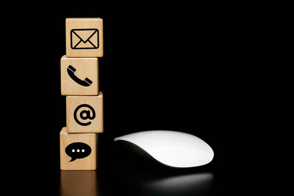 Website page contact us or e-mail marketing Customer support concept, hotline Contact us people connection. cube wood with the address, call phone, address, icons, with a mouse on a dark background.                