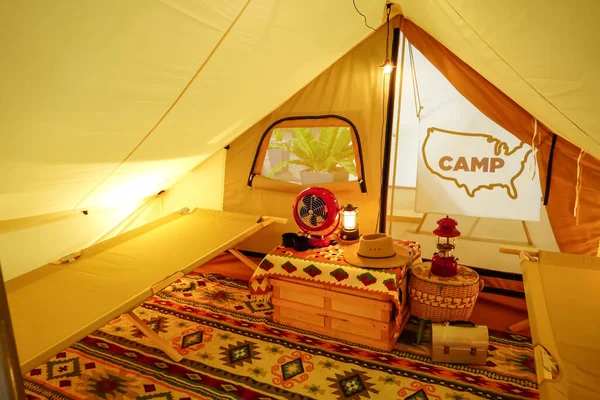 Glamping inside Tent in a warm yellow light.