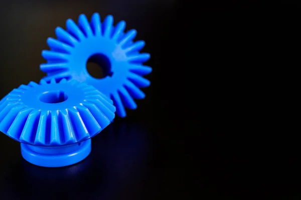 Siyah zemin üzerinde plastikten yapılmış Mavi Bevel dişlileri.