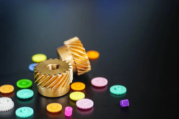 Helical Gears Brass and Plastic gears, On a black background, the concept of work movement.