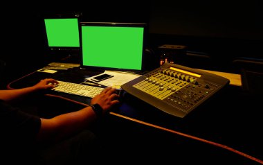 sound engineer working in digital audio and video editing post production studio.Green screen.Selective focus.                                clipart