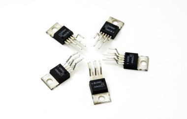Çeşitli elektronik bileşenler, transistörler beyaz arkaplana yakın plan.