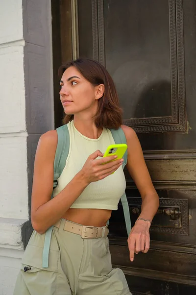 Young woman with mobile phone travels through the streets of Istanbul in a good mood enjoying the beauty of the city