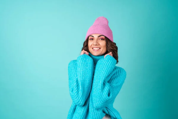 若いです女性の居心地の良い肖像画で編んだ青いセーターとピンクの帽子で明るい化粧 — ストック写真
