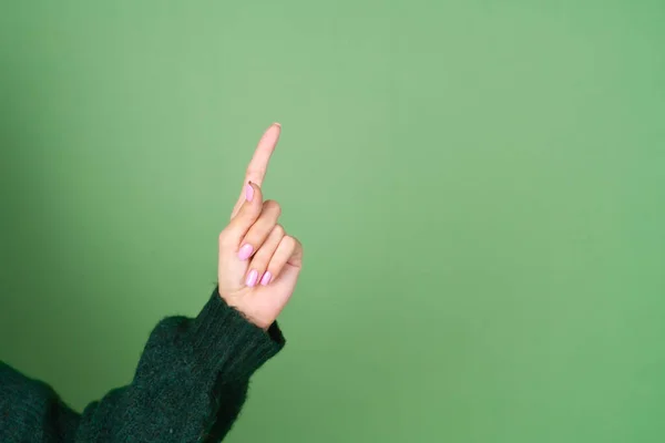 Frauenhand Auf Grünem Hintergrund Pullover Zeigt Nach Oben — Stockfoto