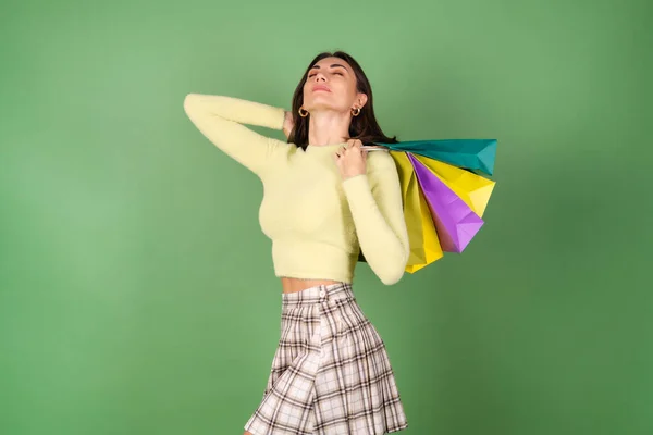 Young Woman Green Background Yellow Sweater Plaid Skirt Holding Shopping — Stock Photo, Image