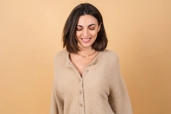 若いです女性上のベージュ背景で柔らかい居心地の良いセーターとともに昼間の専門家の化粧かわいい笑顔 — ストック写真