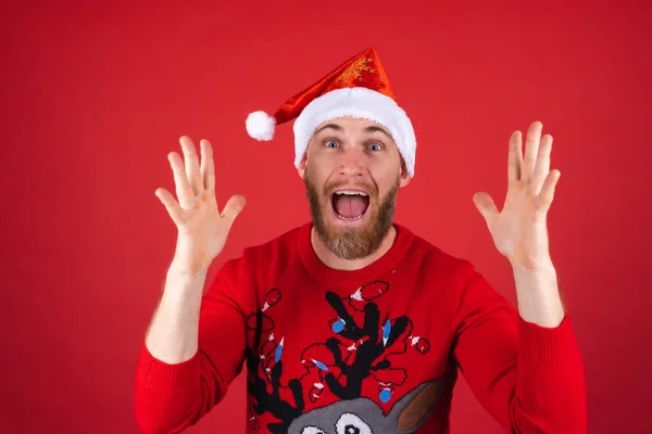 Hombre Barba Roja Sombrero Santa Suéter Navidad Sobre Fondo Rojo —  Fotos de Stock