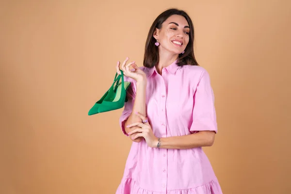 一个穿着米色背景的粉色连衣裙的年轻女子的画像 脸上闪烁着灿烂的妆容 带着浪漫的绿色抽水机 — 图库照片