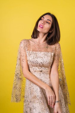 Yeni yıl arifesinde genç bir kadın parlak parlak bej bir elbise Noel 'i kutluyor, parlak pembe ruj dudak parlatıcısı.