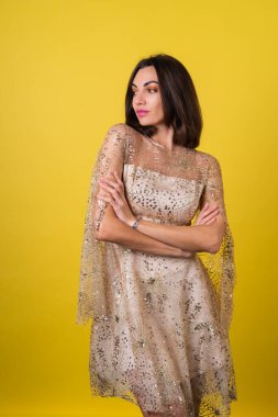 Yeni yıl arifesinde genç bir kadın parlak parlak bej bir elbise Noel 'i kutluyor, parlak pembe ruj dudak parlatıcısı.