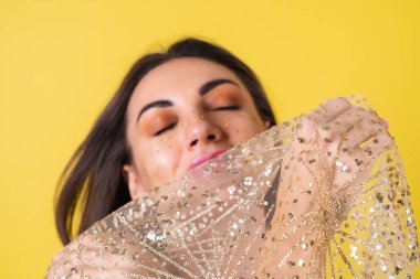 Yeni yıl arifesinde genç bir kadın parlak parlak bej bir elbise Noel 'i kutluyor, parlak pembe ruj dudak parlatıcısı.
