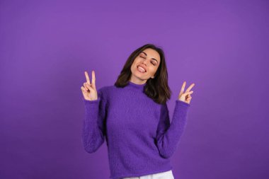 Young woman in a purple soft cozy sweater on the background of cute smiling cheerfully, in high spirits, confident smile, bright makeup with lipstick