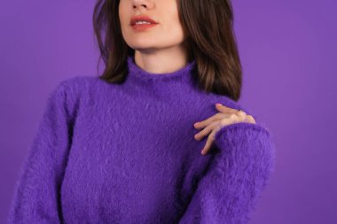 Young woman in a purple soft cozy sweater on the background of cute smiling cheerfully, in high spirits, confident smile, bright makeup with lipstick