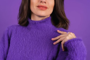 Young woman in a purple soft cozy sweater on the background of cute smiling cheerfully, in high spirits, confident smile, bright makeup with lipstick