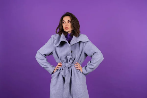 紫の背景にグレーのコートの若い女性がポーズ 居心地の良い 暖かい 秋の冬のスタイル — ストック写真
