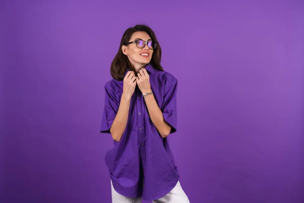 紫色の背景に短い袖を持つシャツの若い女性 化粧と 彼女の唇に口紅や背景にポーズをとるスタイリッシュなメガネ — ストック写真