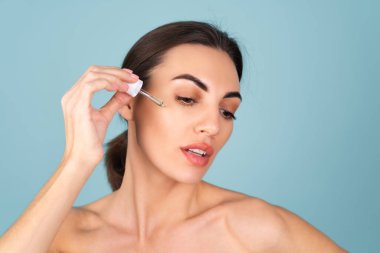 Mükemmel ciltli ve doğal makyajlı üstsüz kadının yakın güzellik portresi, gençlik ve cilt suyu için serum, kozmetik yağlı damlatıcı.