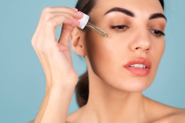 Mükemmel ciltli ve doğal makyajlı üstsüz kadının yakın güzellik portresi, gençlik ve cilt suyu için serum, kozmetik yağlı damlatıcı.