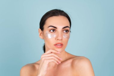 Mükemmel ciltli, doğal makyajlı, gözlerinin altında parlak lekeler olan üstsüz bir kadının güzel portresi cildinizi nemlendirir ve yüzünüzün şişkinliğini giderir.