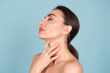 Mükemmel ciltli, doğal makyajlı, gözlerinin altında parlak lekeler olan üstsüz bir kadının güzel portresi cildinizi nemlendirir ve yüzünüzün şişkinliğini giderir.