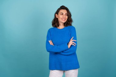 Woman in a blue knitted sweater and natural make-up, curly short hair, with an infectious radiant smile in high spirits clipart