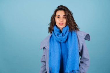İlkbahar portresi, mavi örgü süveter, atkı ve gri ceketli bir kadın, bahar beklentisiyle şık poz veriyor.