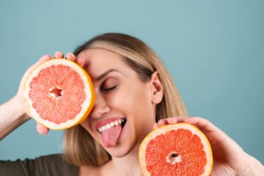 Mükemmel ciltli, doğal makyajlı, çıplak dudaklı, taze narenciye vitamini ve greyfurt içeren üstsüz kadın portresi.