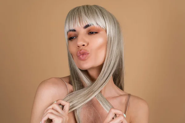 Blondynka Długimi Włosami Grzywką Nagim Makijażem Jedwabnej Sukience Beżowym Tle — Zdjęcie stockowe