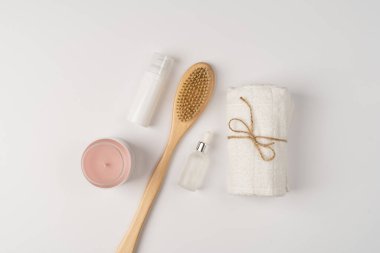 Düz banyo kozmetik seti. Çevre dostu ahşap fırça, temiz temiz havlu ve beyaz arka planda mum..