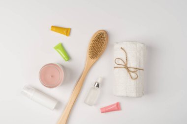 Düz banyo kozmetik seti. Çevre dostu ahşap fırça, temiz temiz havlu ve beyaz arka planda mum..