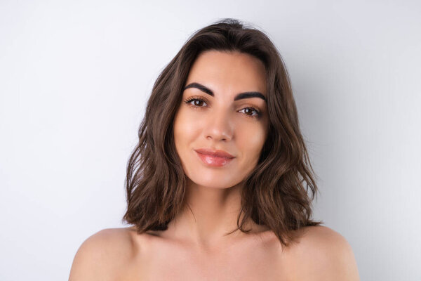 Close-up beauty portrait of a topless woman with perfect skin and natural make-up