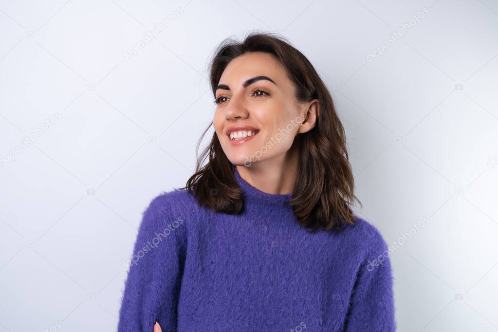 Young woman in a purple soft cozy sweater on the background of cute smiling cheerfully, in high spirits, confident smile	