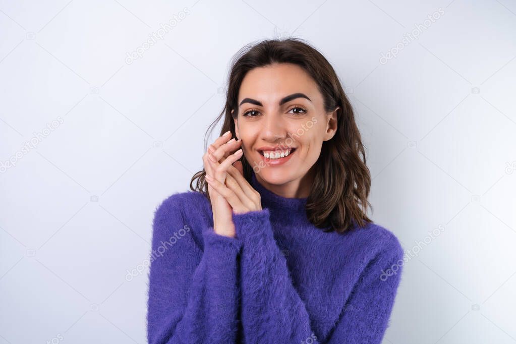 Young woman in a purple soft cozy sweater on the background of cute smiling cheerfully, in high spirits, confident smile	
