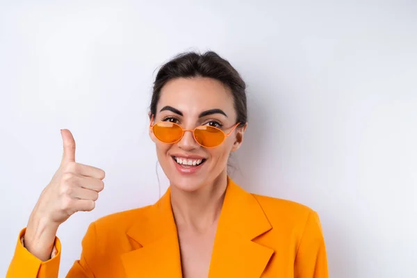 유행하는 스타일의 안경을 여자와 배경에 오렌지색 덩치의 재킷을 — 스톡 사진