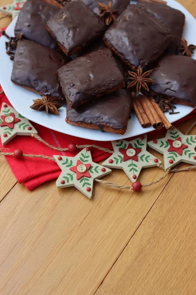 İtalyan geleneksel şenlik kurabiyelerinin adı Mostaccioli ya da Mustaccioli. Tabakta kırmızı peçete ve ahşap masa süsleri var. Noel kurabiyeleri mith Pisto, çeşitli baharatların bir karışımı