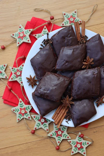 İtalyan geleneksel şenlik kurabiyelerinin adı Mostaccioli ya da Mustaccioli. Tabakta kırmızı peçete ve ahşap masa süsleri var. Noel kurabiyeleri mith Pisto, çeşitli baharatların bir karışımı