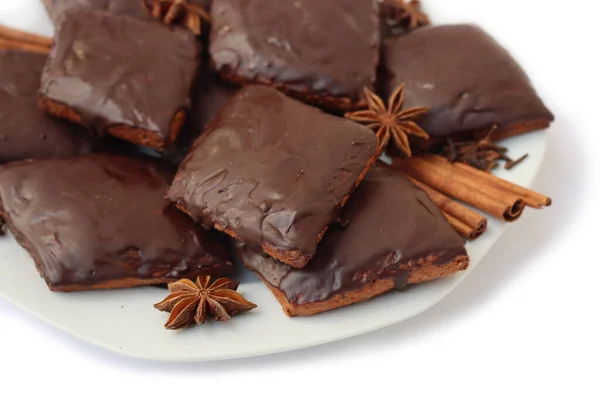 Beyaz arka planda izole edilmiş bir tabakta Mostaccioli veya Mustaccioli adı verilen İtalyan geleneksel festival kurabiyeleri. Noel kurabiyeleri mith Pisto, çeşitli baharatların bir karışımı