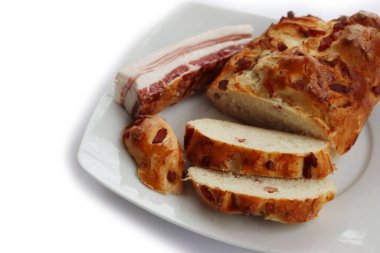 Beyaz arka planda pastırmalı fırınlanmış ve dilimlenmiş ekmek.