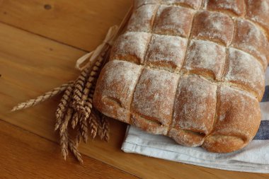 Geleneksel ev yapımı İtalyan ekmeği ahşap masa üzerinde buğday gevreği kulakları süslemesi