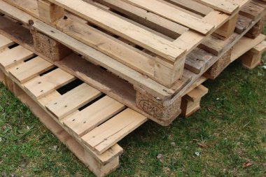 Yeşil çayır üzerinde bir yığın ahşap paletler