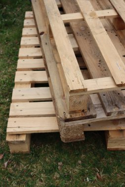 Yeşil çayır üzerinde bir yığın ahşap paletler