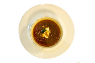 Üstünde mayonez olan bir tabakta borş.