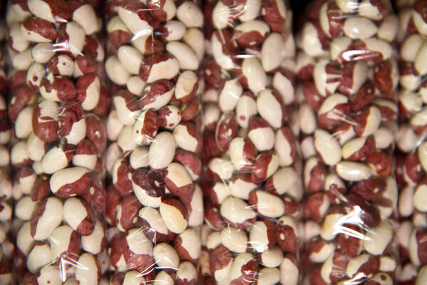 Полка в продуктовом магазине с пакетами бобов, риса, арахиса, изюма, чечевицы и других сортов