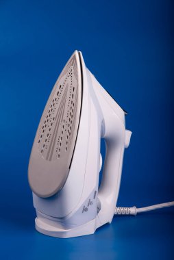 Mavi arka planda beyazlı modern buharlı elektrikli ütü