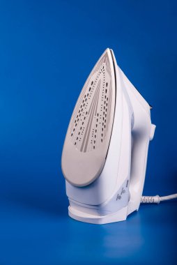 Mavi arka planda beyazlı modern buharlı elektrikli ütü