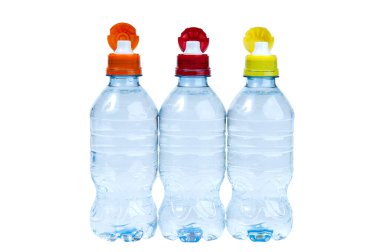 Kullanıma hazır boynu açık üç plastik içme suyu şişesi ve beyaz izole edilmiş arka planda kırmızı, sarı ve turuncu renkli boyunlar. Üç renkli şişe..
