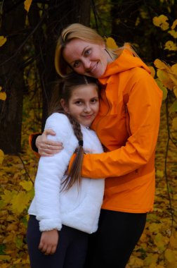 Açık hava parkında gülümseyen bir anne ve kızın portresi.