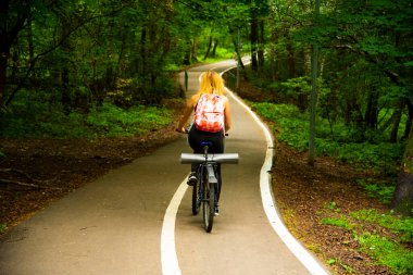 Bisikletle seyahat eden bir yaz gününde parkta sarışın.
